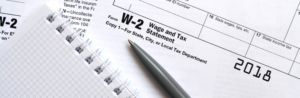 The Pen and Notebook on the Tax Form W-2 Wage and Tax Statement.