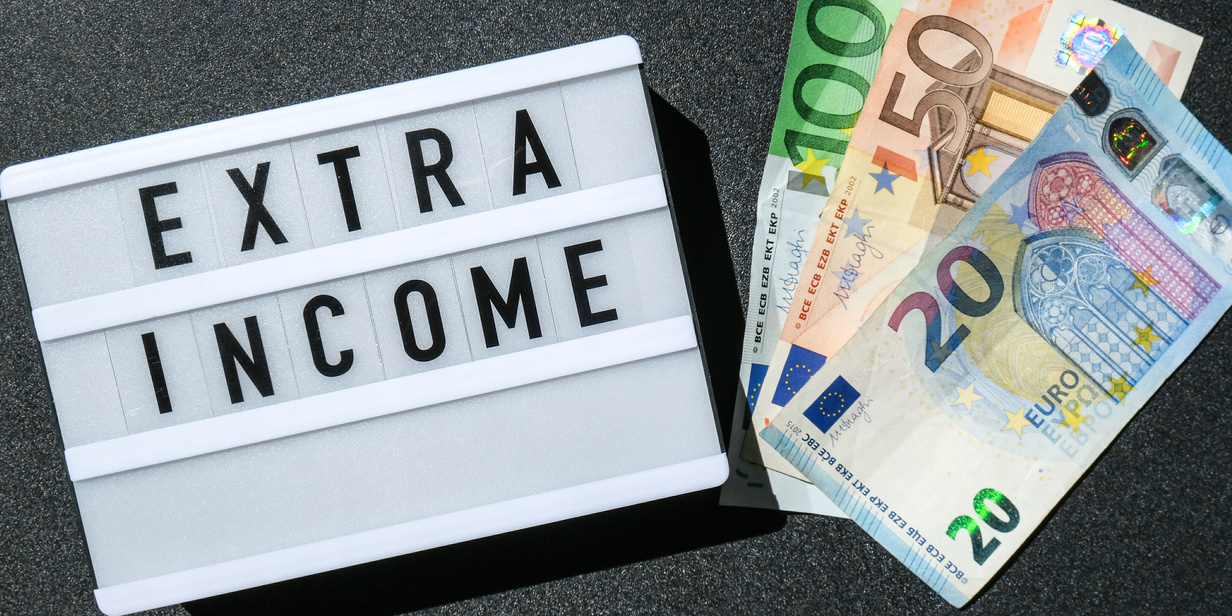 Lightbox Board with Word EXTRA INCOME in Black Letters around Euro Banknotes. Money, Business, Finance, Investment, Saving