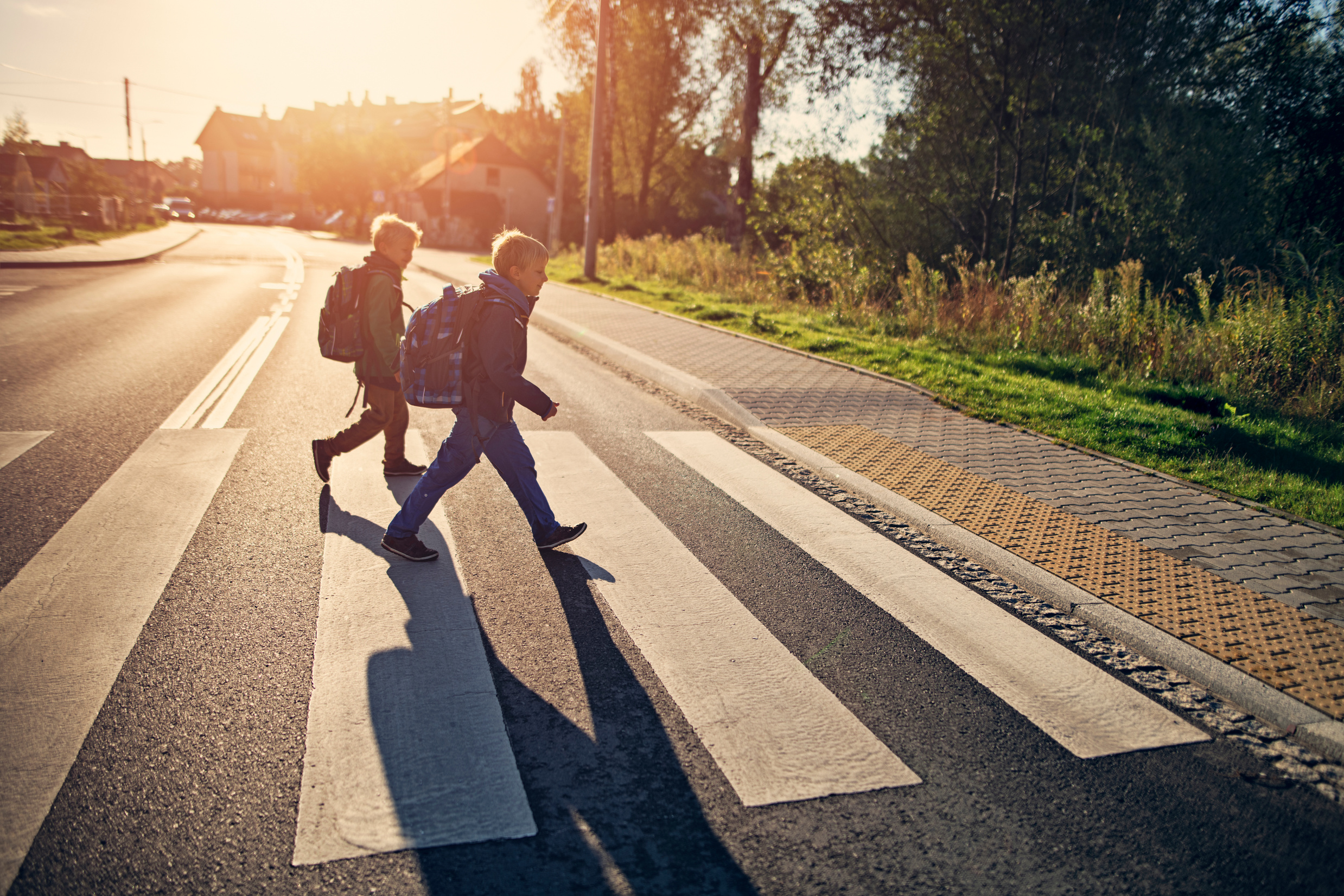 School boys walking on zebra crossing on way to school